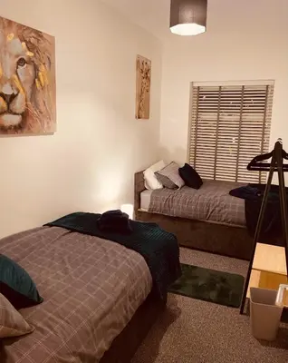 a bedroom with two beds and a window at Luxury Suite 3 bed apartment sleeps 6-8 in Blackpool