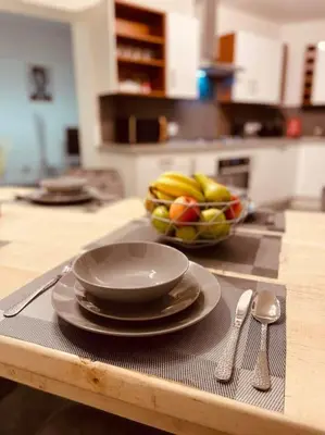 a table with plates and a bowl of fruit on it at Luxury Suite 3 bed apartment sleeps 6-8 in Blackpool