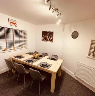 a dining room with a wooden table and chairs at Luxury Suite 3 bed apartment sleeps 6-8 in Blackpool