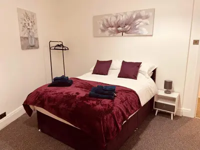a bedroom with a bed with a red blanket at Luxury Suite 3 bed apartment sleeps 6-8 in Blackpool