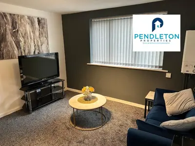 a living room with a tv and a couch and a table at Cosy Central APT, 10 Min Walk to UCLAN and Library in Preston