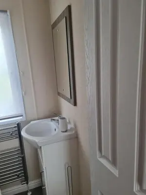 a bathroom with a sink and a mirror on the wall at Nicks and Carmels by the Lake in Carnforth