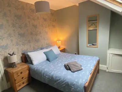 a bedroom with a bed with a blue comforter at Villa with Park Views close to Liverpool Centre in Liverpool
