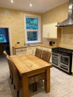 a kitchen with a wooden table with chairs and a stove at Villa with Park Views close to Liverpool Centre in Liverpool