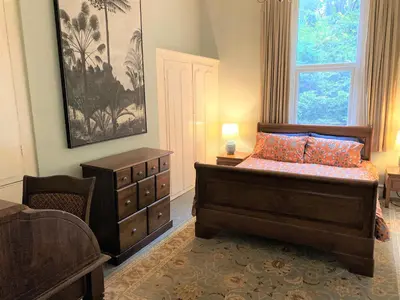 a bedroom with a bed and a dresser and a window at Villa with Park Views close to Liverpool Centre in Liverpool