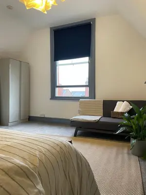 a bedroom with a couch and a window at Deluxe Huge Detached House with Parking, sleeps up to 30 people, 2m from Liverpool City Centre in Liverpool