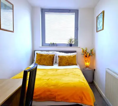 a bedroom with a yellow bed with a window at Sidemersey Livings- Central and Quiet 2-Bedroom Flat with a View in Liverpool