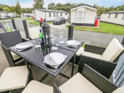 a table and chairs on the deck of a balcony at 3 Yealands in Carnforth