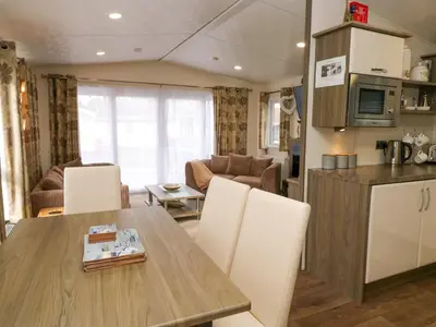 a kitchen and living room with a table and chairs at 3 Yealands in Carnforth