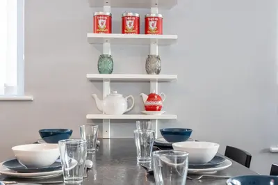 a dining room table with plates and glasses on it at GuestReady - Modern stay in Bispham House in Liverpool