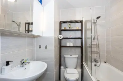a bathroom with a sink and a toilet and a tub at GuestReady - Modern stay in Bispham House in Liverpool