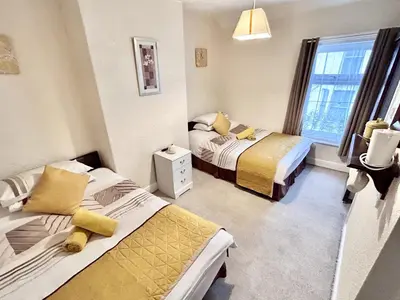 a bedroom with two beds and a window at Aysgarth House in Blackpool