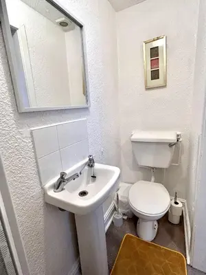 a white bathroom with a sink and a toilet at Aysgarth House in Blackpool