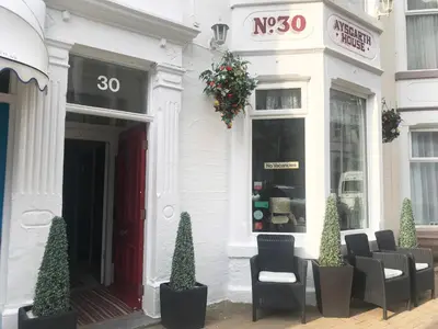 a white building with chairs in front of a store at Aysgarth House in Blackpool