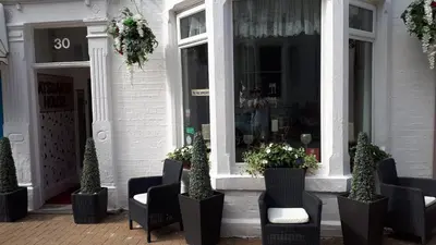 a store front with chairs and a person in the window at Aysgarth House in Blackpool