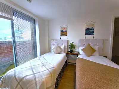 two beds in a room with a window at Sidemersey Livings- Convenient 1-Bedroom Flat with a View, Central Liverpool in Liverpool