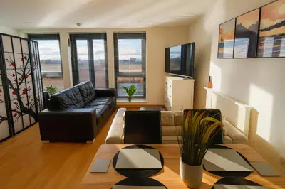 a living room with a couch and a table at Sidemersey Livings- Convenient 1-Bedroom Flat with a View, Central Liverpool in Liverpool