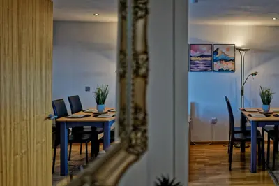a dining room with tables and chairs and a mirror at Sidemersey Livings- Convenient 1-Bedroom Flat with a View, Central Liverpool in Liverpool