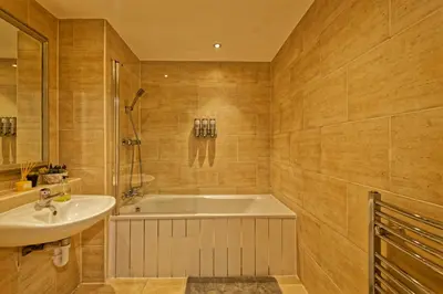 a bathroom with a bath tub and a sink at Sidemersey Livings- Convenient 1-Bedroom Flat with a View, Central Liverpool in Liverpool