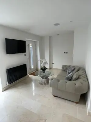 a white living room with a couch and a tv at Castle St Mews of Southport - 2 bed townhouse in Southport