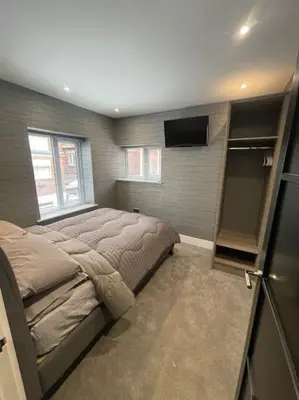 a bedroom with a bed and a television in it at Castle St Mews of Southport - 2 bed townhouse in Southport