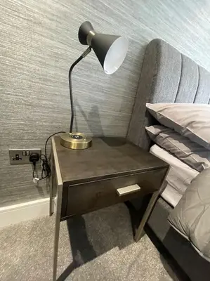 a table with a lamp on it next to a bed at Castle St Mews of Southport - 2 bed townhouse in Southport