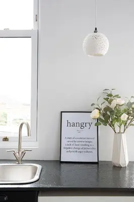 a kitchen counter with a pharmacy sign and a vase of flowers at Beautiful first floor apartment in Poulton le Fylde