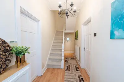 a hallway with white walls and a white door and stairs at Beech Apparent lovely spacious double room in Liverpool