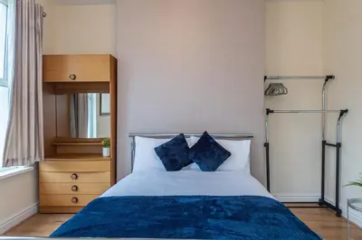 a bedroom with a bed with two blue pillows at Beech Apparent lovely spacious double room in Liverpool