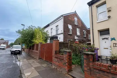 a car parked on a street next to a house at Beech Apparent lovely spacious double room in Liverpool