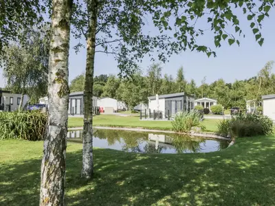 a view of a park with houses and a pond at Lilac Lodge in Carnforth