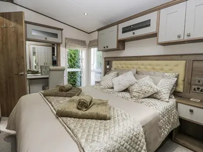 a bedroom with two beds with towels on them at Lilac Lodge in Carnforth