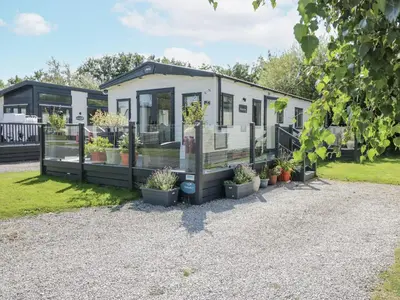a tiny house with potted plants in front of it at Lilac Lodge in Carnforth