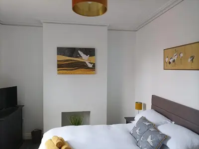 a bedroom with a bed and a picture on the wall at Victorian Renovation Room 1 in Liverpool