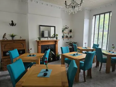 a dining room with wooden tables and blue chairs at Victorian Renovation Room 1 in Liverpool