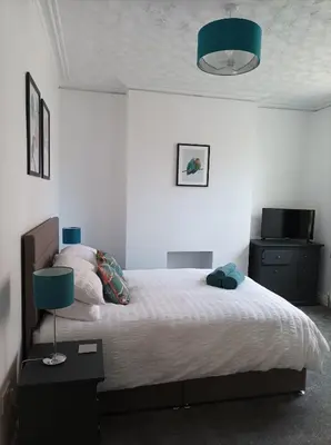 a bedroom with a large bed with a blue lamp at Victorian Renovation Room 4 in Liverpool