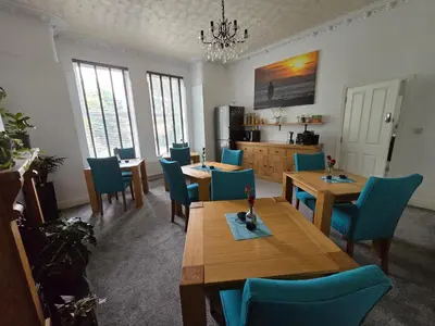 a dining room with wooden tables and blue chairs at Victorian Renovation Room 5 in Liverpool