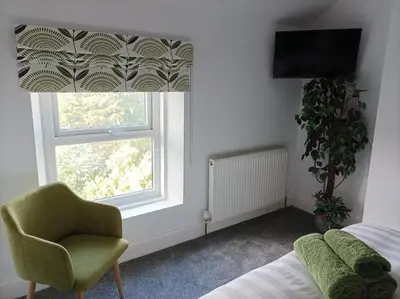 a bedroom with a bed and a chair and a window at Victorian Renovation Room 5 in Liverpool