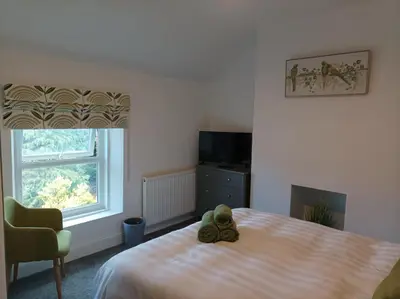 a teddy bear sitting on a bed in a bedroom at Victorian Renovation Room 5 in Liverpool
