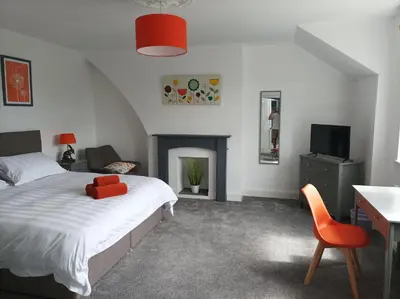 a bedroom with a bed and a desk and a tv at Victorian Renovation Room 6 in Liverpool
