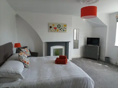 a bedroom with a large bed with a fireplace at Victorian Renovation Room 6 in Liverpool