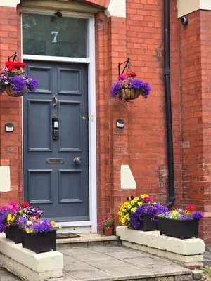 a blue door on a brick house with flowers at Victorian Renovation Room 7 in Liverpool