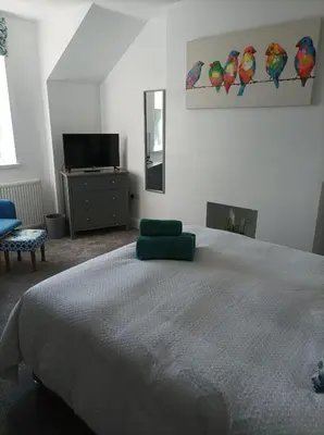 a bedroom with a bed with a green pillow on it at Victorian Renovation Room 7 in Liverpool