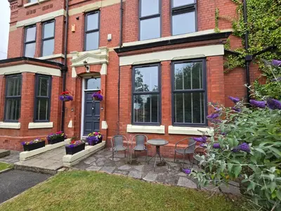 a brick house with a table and chairs in the yard at Victorian Renovation Room 7 in Liverpool