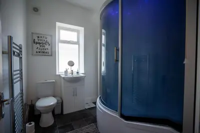 a bathroom with a toilet and a glass shower at Cavendish Cat and Gaming House in Blackpool