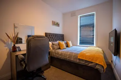 a bedroom with a bed and a desk and a chair at Cavendish Cat and Gaming House in Blackpool