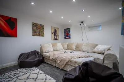 a living room with a couch and posters on the wall at Cavendish Cat and Gaming House in Blackpool