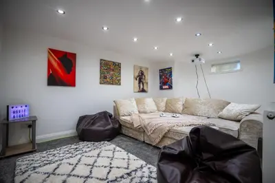 a living room with a couch and paintings on the wall at Cavendish Cat and Gaming House in Blackpool