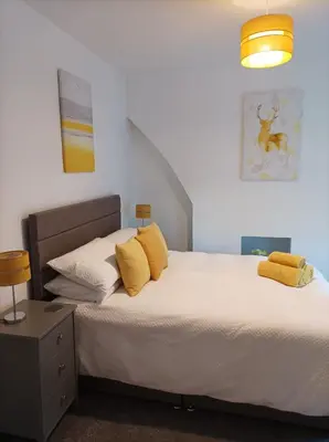 a bedroom with a large bed with yellow pillows at Victorian Renovation Room 8 in Liverpool