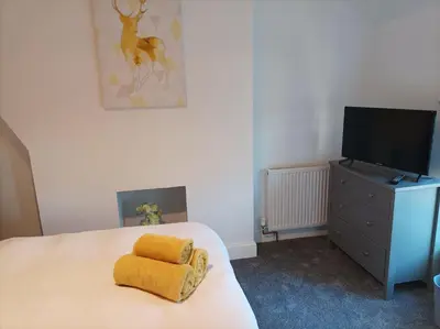 a bedroom with a bed with yellow towels on it at Victorian Renovation Room 8 in Liverpool
